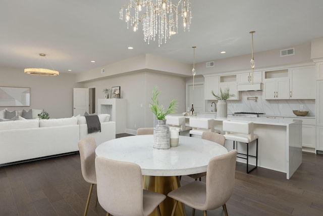 dining room with dark wood finished floors, visible vents, recessed lighting, and a notable chandelier