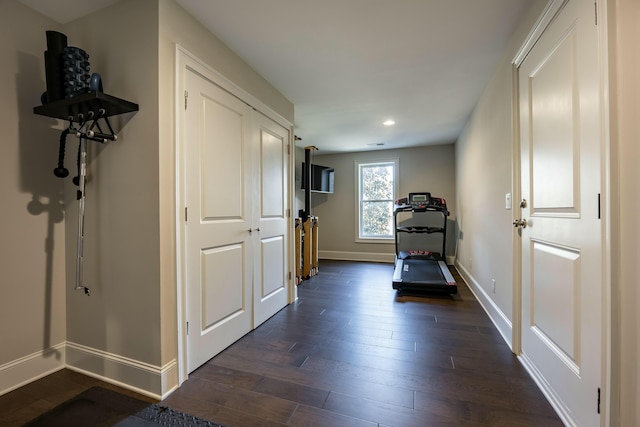 workout area featuring recessed lighting, baseboards, and dark wood-style flooring