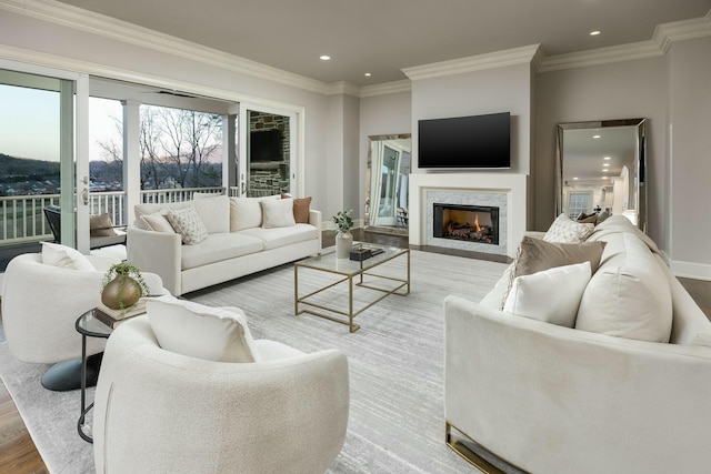 living room with ornamental molding, a warm lit fireplace, wood finished floors, recessed lighting, and baseboards