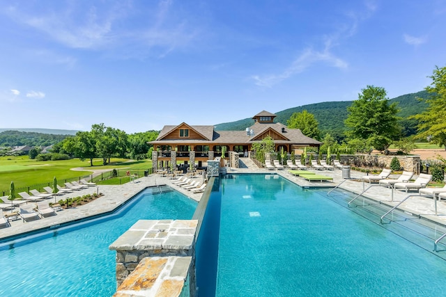 pool with a mountain view, a yard, a patio area, and fence