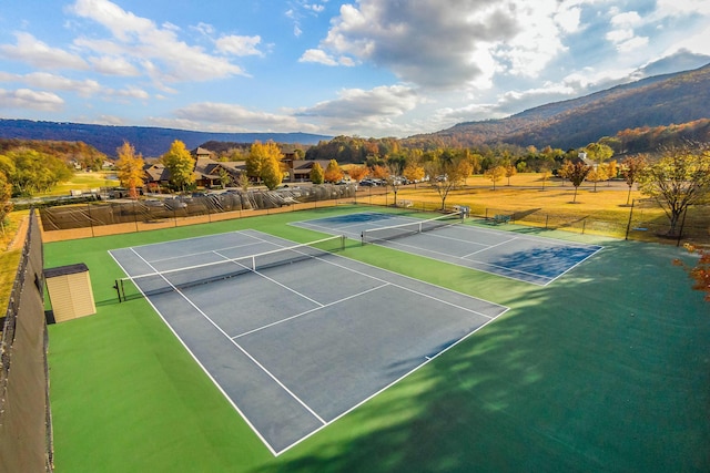 view of sport court with fence and a mountain view