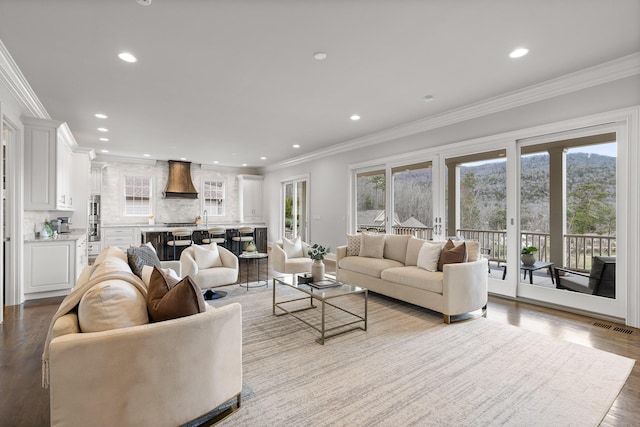 living area with crown molding, recessed lighting, and a wealth of natural light