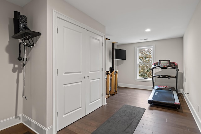 exercise room featuring dark wood finished floors, recessed lighting, visible vents, and baseboards