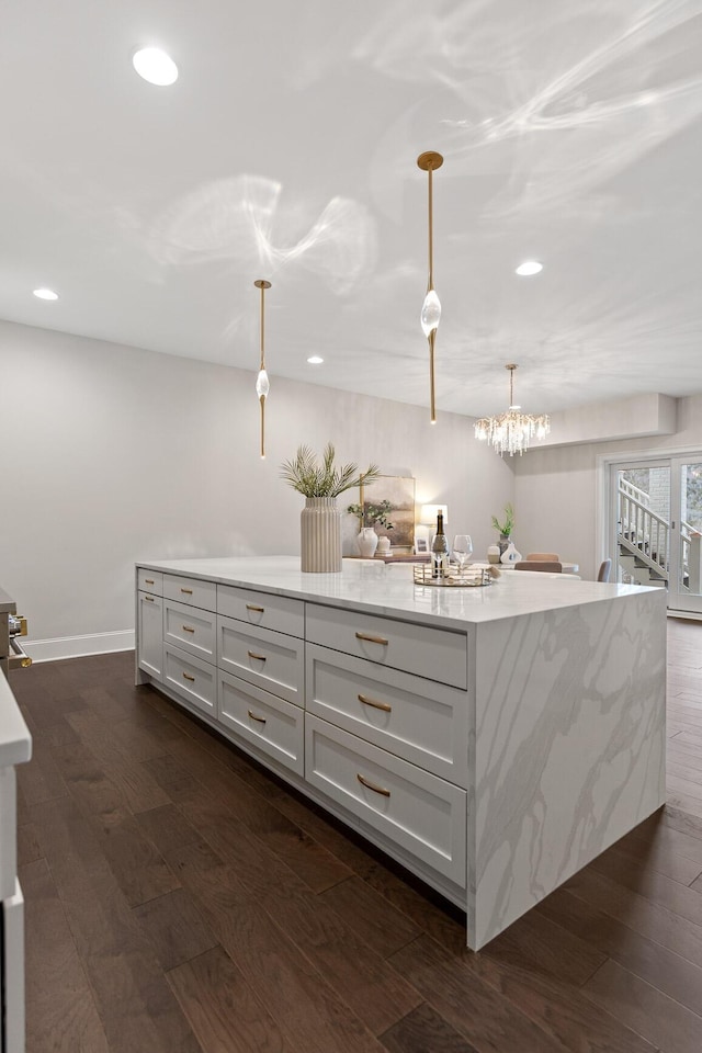 interior space with recessed lighting, baseboards, dark wood-type flooring, and pendant lighting