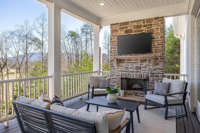 wooden terrace with an outdoor living space with a fireplace