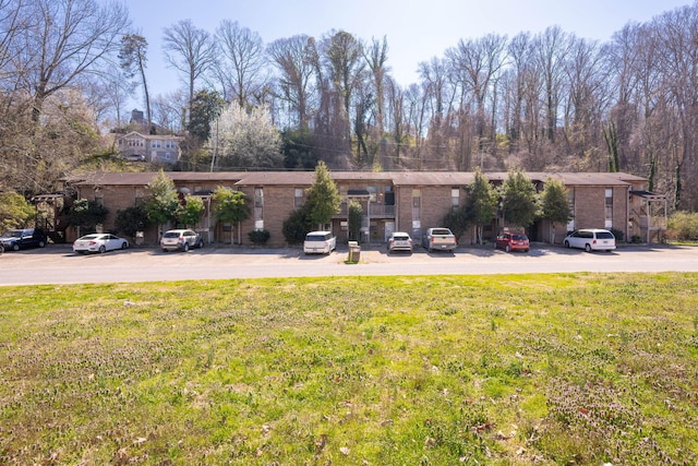 view of front of home with a front yard and brick siding