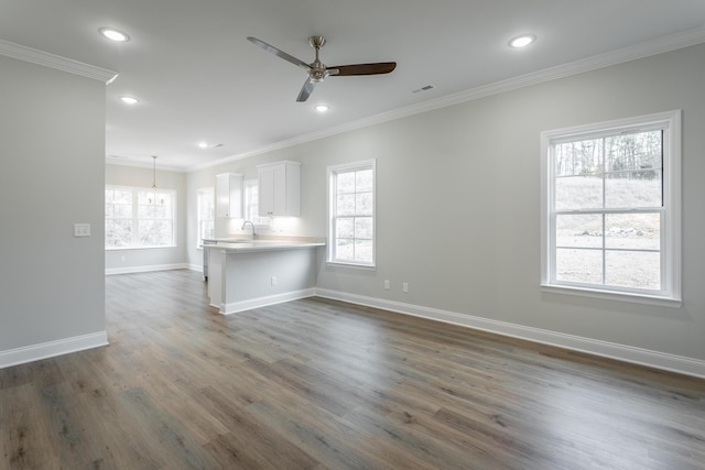 unfurnished living room with crown molding, visible vents, dark wood-type flooring, ceiling fan, and baseboards