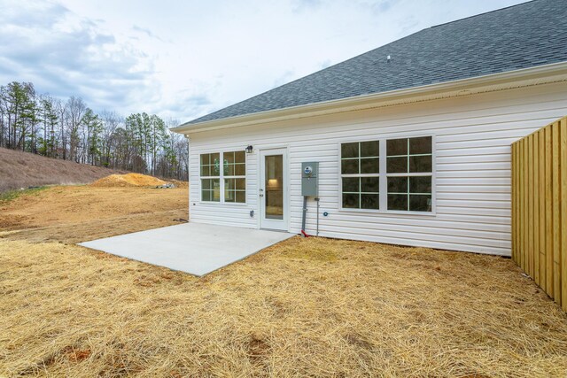 rear view of property featuring a patio area and a shingled roof