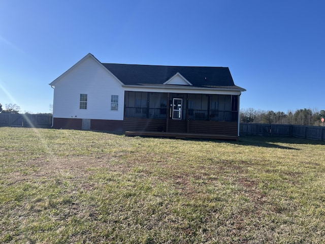 view of front of home with a front lawn, fence, and a sunroom