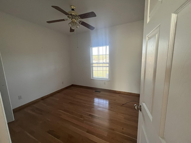 empty room with ceiling fan, baseboards, and wood finished floors