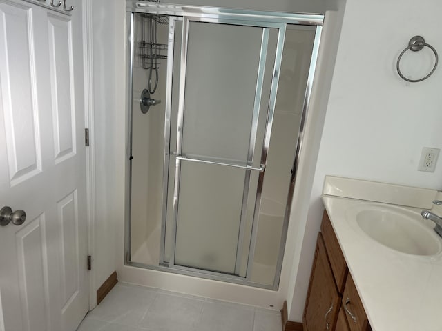 bathroom with tile patterned flooring, a shower stall, and vanity