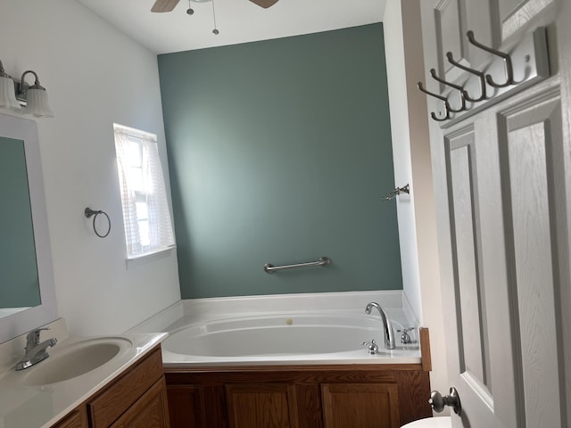 bathroom with a ceiling fan, vanity, and a bath