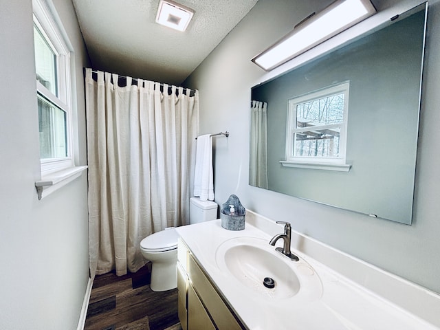 full bath featuring a shower with shower curtain, toilet, wood finished floors, a textured ceiling, and vanity