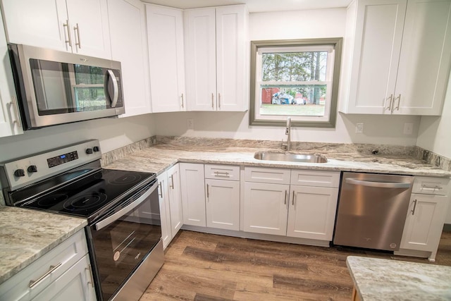 kitchen featuring white cabinetry, appliances with stainless steel finishes, dark wood-type flooring, and a sink