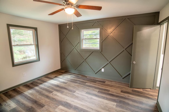 spare room with baseboards and wood finished floors