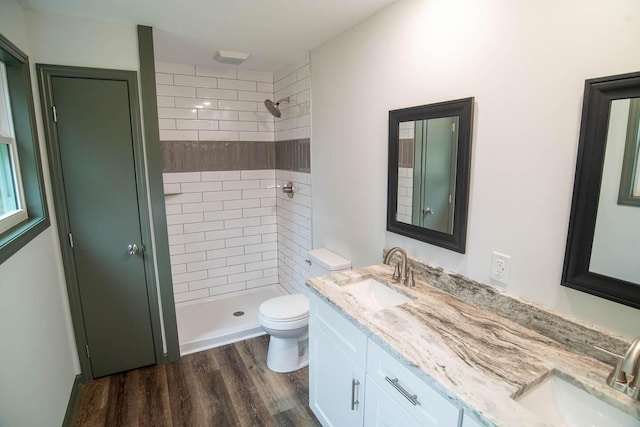 full bath with wood finished floors, a stall shower, a sink, and toilet