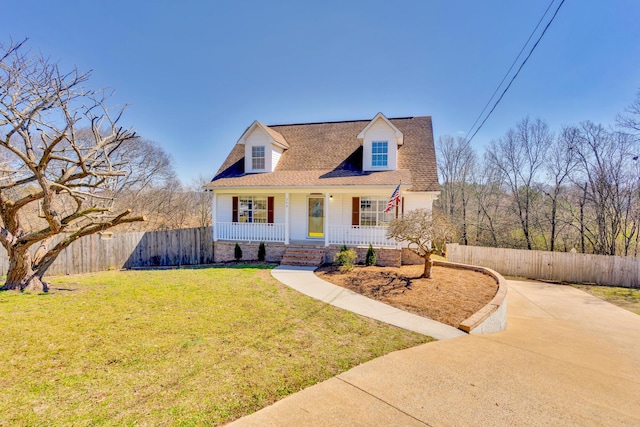 cape cod house with covered porch, a shingled roof, a front yard, and fence