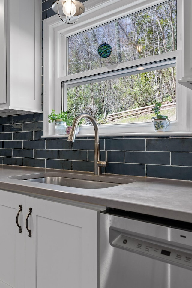 kitchen featuring a sink, white cabinets, decorative backsplash, and dishwasher