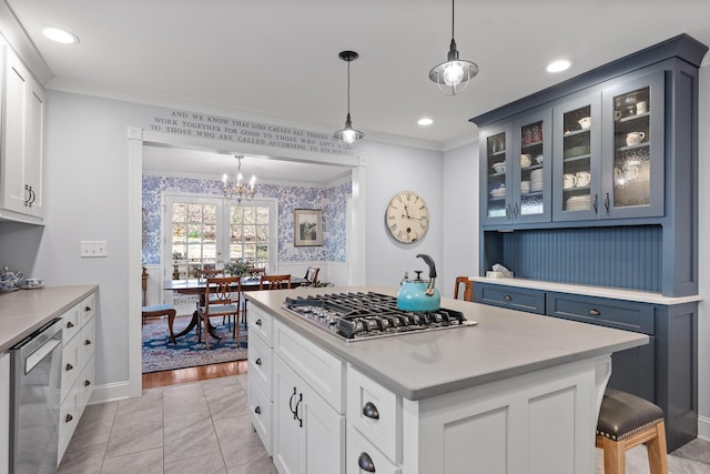 kitchen with glass insert cabinets, ornamental molding, hanging light fixtures, stainless steel appliances, and light countertops