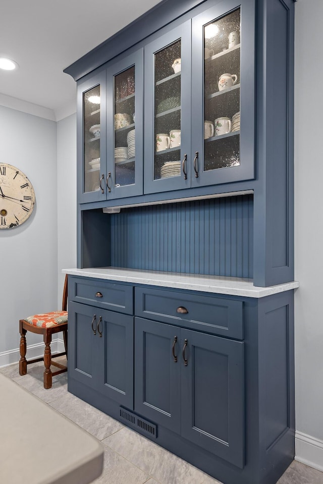 bar with ornamental molding, visible vents, and baseboards