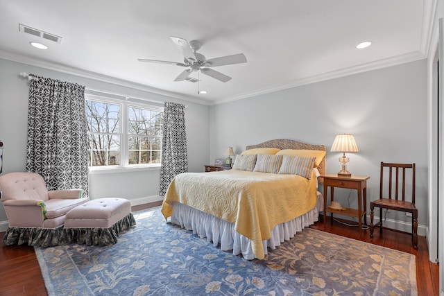 bedroom featuring baseboards, crown molding, visible vents, and wood finished floors