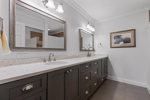 bathroom with ornamental molding, a sink, baseboards, and double vanity