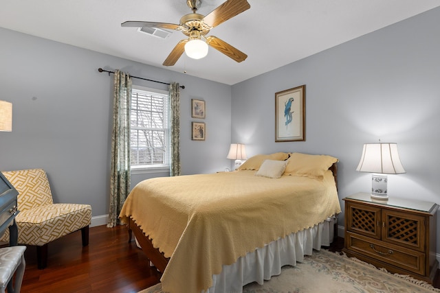 bedroom featuring visible vents, ceiling fan, baseboards, and wood finished floors