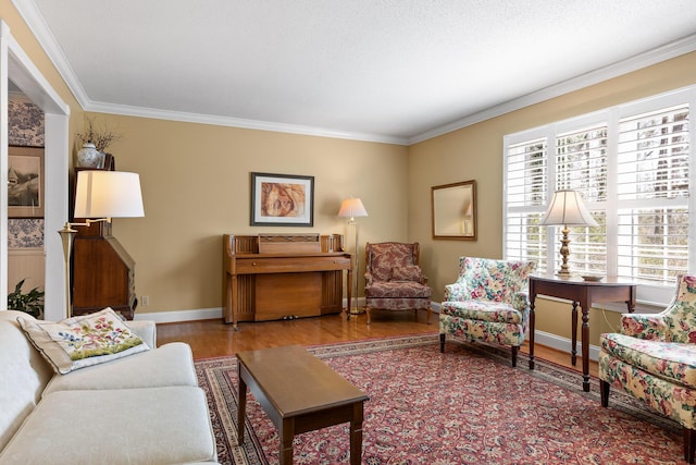 living area featuring crown molding, baseboards, and wood finished floors