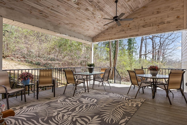 wooden deck featuring outdoor dining area and a ceiling fan