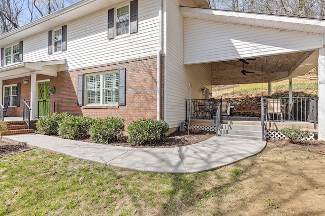 view of home's exterior with ceiling fan, a porch, and brick siding