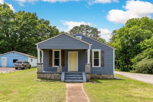 view of front of property with a garage, crawl space, covered porch, an outdoor structure, and a front lawn