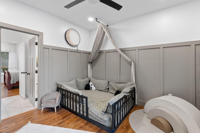 bedroom featuring recessed lighting, marble finish floor, a decorative wall, and ceiling fan