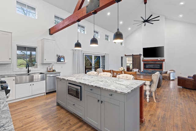 kitchen featuring hardwood / wood-style flooring, stainless steel appliances, a sink, and a center island