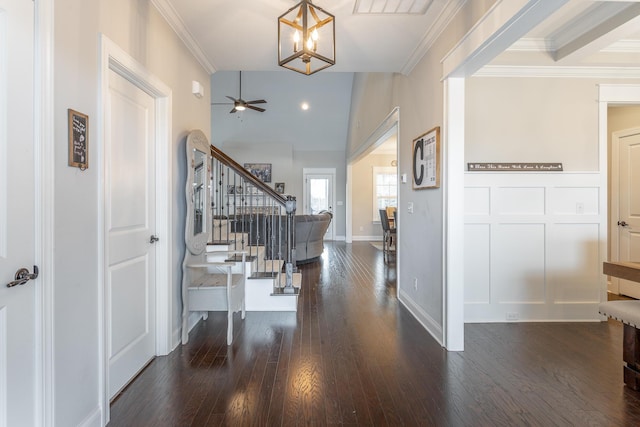 entrance foyer featuring a ceiling fan, dark wood-style flooring, crown molding, and stairs