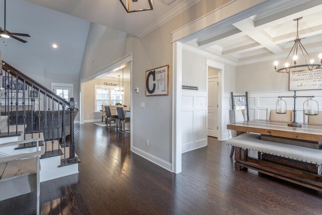 dining space with ceiling fan with notable chandelier, dark wood-style flooring, coffered ceiling, stairway, and crown molding