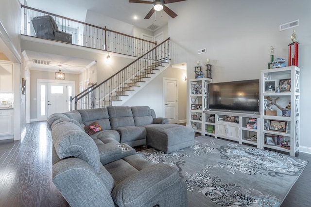 living room with stairway, visible vents, and wood finished floors