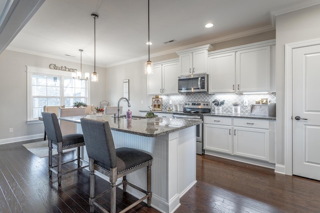 kitchen featuring visible vents, decorative backsplash, appliances with stainless steel finishes, dark wood-type flooring, and a sink