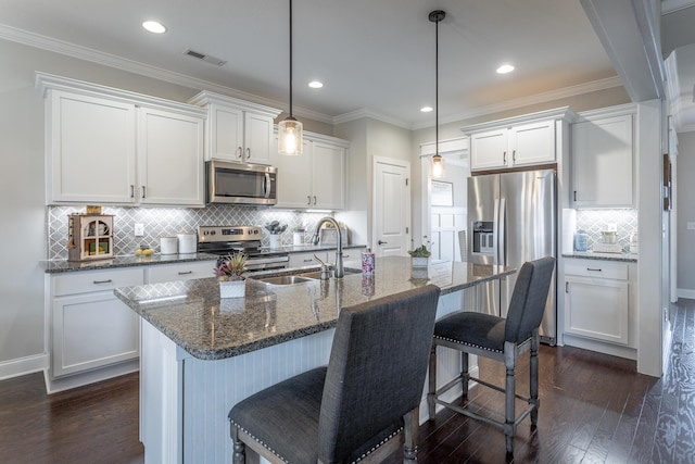 kitchen featuring dark wood-style floors, visible vents, appliances with stainless steel finishes, white cabinets, and a sink