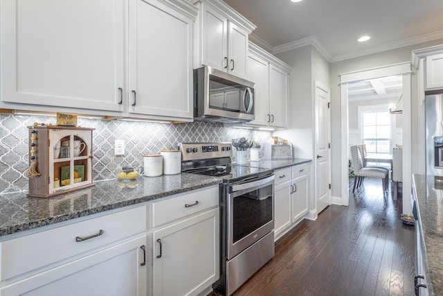 kitchen with stainless steel appliances, dark wood-type flooring, white cabinetry, ornamental molding, and decorative backsplash