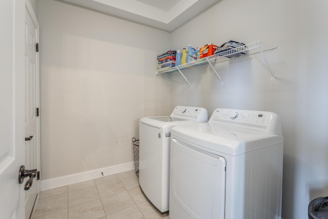 washroom featuring laundry area, light tile patterned floors, baseboards, and washer and dryer