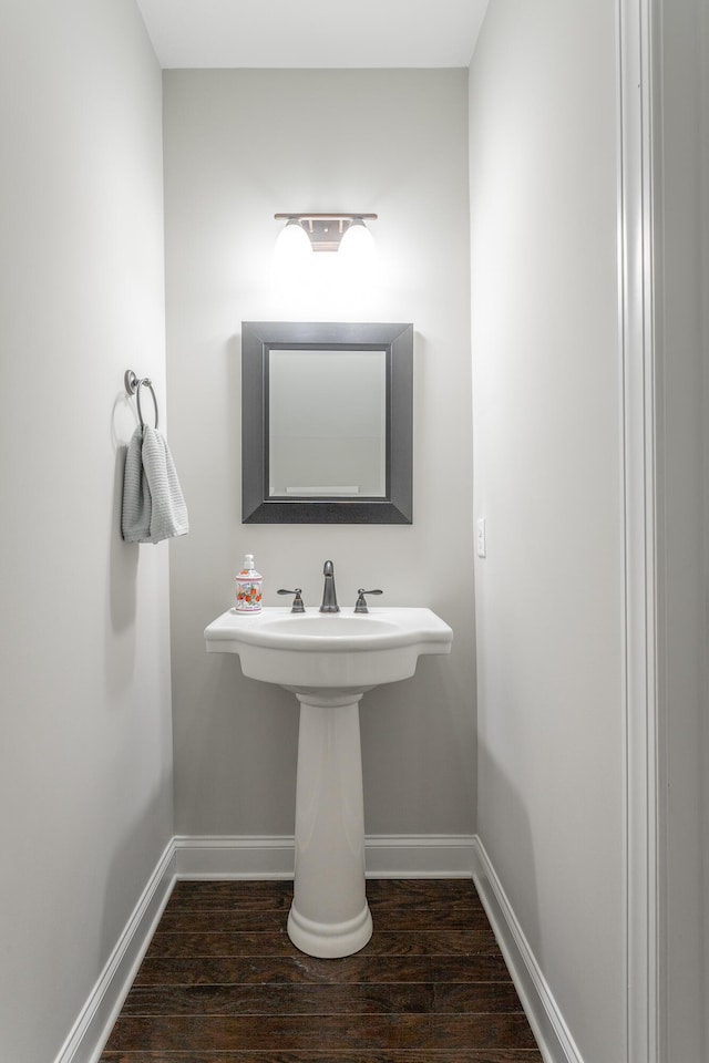 bathroom with wood finished floors and baseboards