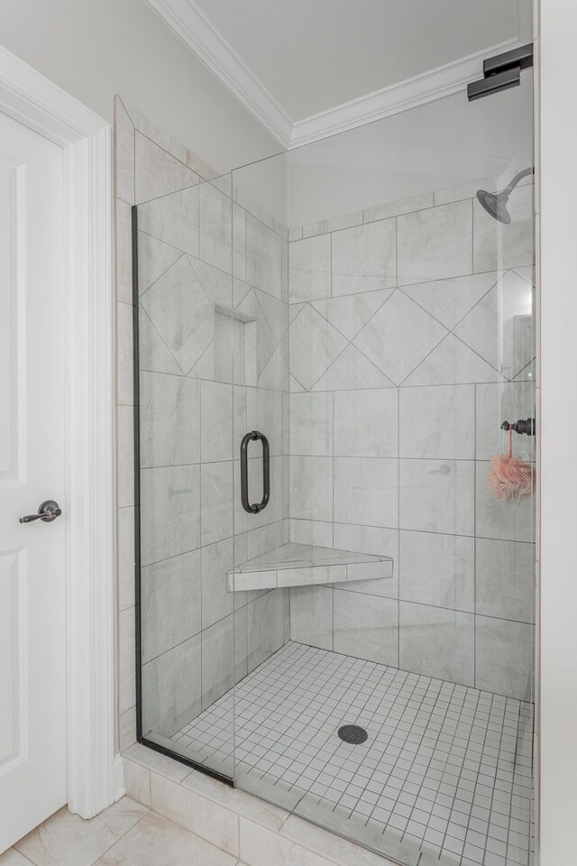 bathroom with a stall shower, tile patterned flooring, and crown molding