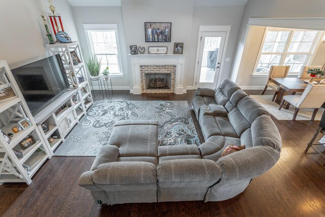 living room with a fireplace, baseboards, and wood finished floors