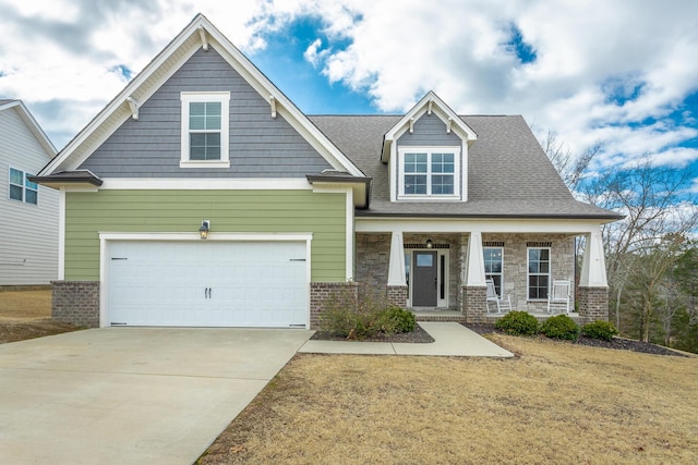 craftsman-style house with covered porch, a garage, brick siding, driveway, and stone siding