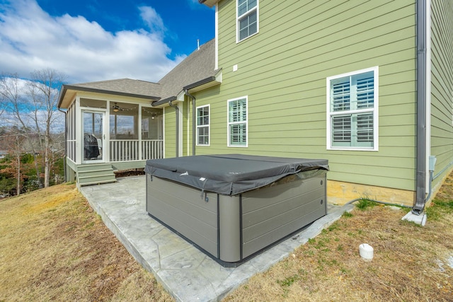 view of patio / terrace featuring a sunroom and a hot tub