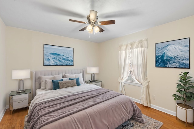 bedroom featuring a ceiling fan, baseboards, and wood finished floors