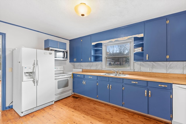 kitchen with blue cabinetry, white appliances, open shelves, and a sink