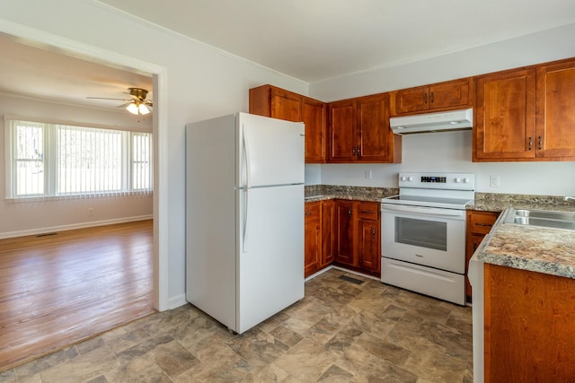 kitchen featuring white appliances, under cabinet range hood, brown cabinets, and a sink