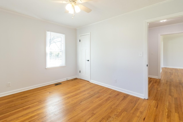 unfurnished room with baseboards, ornamental molding, visible vents, and light wood-style floors