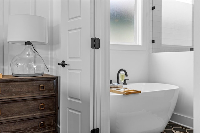 full bathroom with vanity, a soaking tub, baseboards, and tile patterned floors